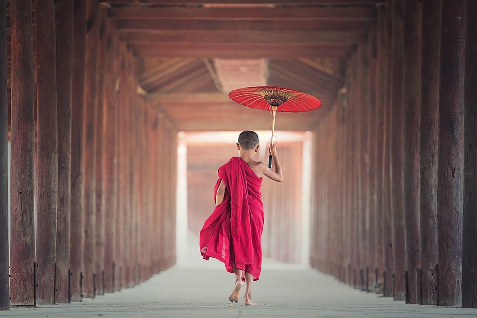 Young monk with umbrella